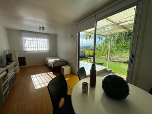a room with a table and chairs and a bedroom at KooColand-Container con mini pileta in Tupungato