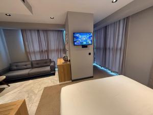 a room with a bed and a couch and a television at SHERLOCK HOMES HOTELS in Istanbul
