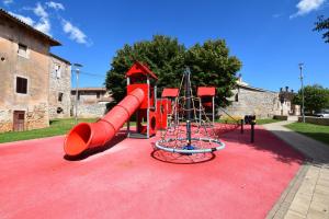 a playground with a red slide on a red carpet at Villa San Rocco with heated pool in Vodnjan