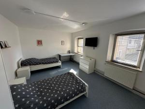 ein Zimmer mit zwei Betten und einem Flachbildfernseher in der Unterkunft Exclusive Monteursunterkunft in Wunsiedel