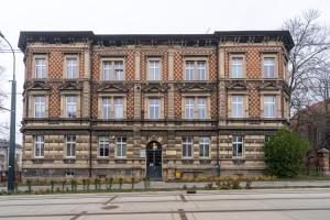 ein großes Backsteingebäude mit einer Tür davor in der Unterkunft Mysłowice Urban Harmony Apartment by BookingHost in Mysłowice