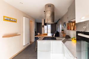 eine Küche mit weißen Schränken und einer Arbeitsplatte in der Unterkunft Le 12 - City Center in Colmar