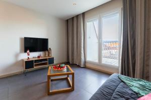 ein Wohnzimmer mit Fernseher und Couchtisch in der Unterkunft Le 12 - City Center in Colmar