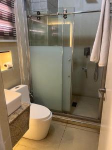 a bathroom with a toilet and a glass shower at Nippon Grand Hotel and Apartment in Abuja