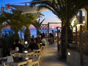 a group of people sitting at tables on the beach at Typic loft Alghero in Alghero