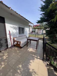 eine Terrasse mit einer Bank und einem Tisch auf dem Balkon in der Unterkunft claudistaudis guesthouse in Vergia + 7 Fotos