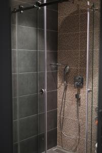 a shower stall with a glass door with a shower at Vila Plamenac in Divčibare