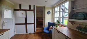 a kitchen with a blue chair next to a door at Jedermanns Nest in Nümbrecht