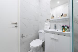 une salle de bains blanche avec toilettes et lavabo dans l'établissement TelMar SeaView, à Oroklini 50 autres photos