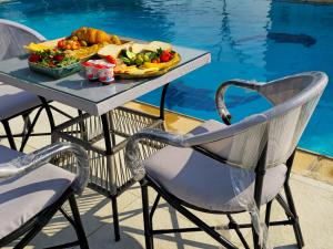 a table with a tray of food on it next to a pool at Nakhil Pyramids Resort in Cairo