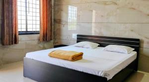 a bed with a towel on it in a room at Annapoorna lodge agumbe in Someshwar