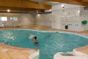 a man in a pool of water in a gym at Mobil Home 3Ch Confort- 6Pers 15min Europa PARK in Boofzheim