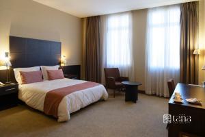 アンタナナリボにあるTANA-Boutique Hôtelの大きなベッドと机があるホテルの部屋 +15枚の写真