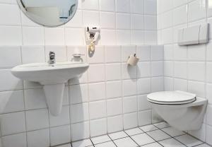 a white bathroom with a toilet and a sink at 33 - 17 Hotelkamer voor twee personen in Marx in Bunkenburg