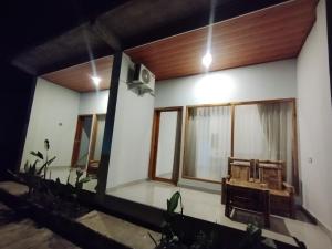 Zimmer mit Stühlen und Fenstern zum Haus in der Unterkunft Ilham Homestay in Kuta Lombok + 9 Fotos
