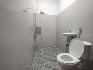 ein weißes Badezimmer mit Toilette und Waschbecken in der Unterkunft Ilham Homestay in Kuta Lombok