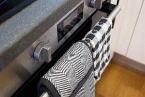 ein schwarz-weißes Handtuch, das an einem Herd hängt in der Unterkunft Modern 1BR Apt - Sleeps 4 - Parking - Balcony in Hoo