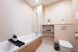 ein Badezimmer mit Badewanne, Toilette und Dusche in der Unterkunft Modern 1BR Apt - Sleeps 4 - Parking - Balcony in Hoo