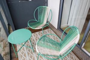 2 grüne Stühle und ein Tisch auf dem Balkon in der Unterkunft Modern 1BR Apt - Sleeps 4 - Parking - Balcony in Hoo