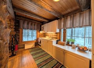 a kitchen with wooden walls and wooden floors and ceilings at Villa Kelotupa in Hossa