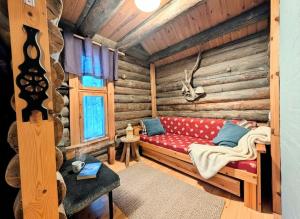 a room with a red couch in a log cabin at Villa Kelotupa in Hossa +42 photos