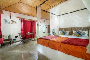 a bedroom with a large bed with a brick wall at Tigergarh Wildlife Resort in Tāla +4 photos