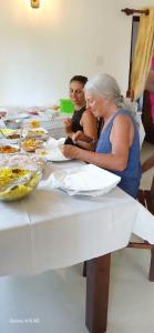 un grupo de personas sentadas a una mesa con comida en ML villa, en Ahangama