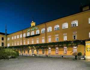 a large yellow building with a clock tower on top at Jet Hotel in Caselle Torinese