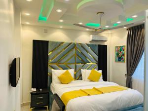 une chambre avec un grand lit avec des oreillers jaunes dans l'établissement Sebrose Star Palace Hotel, à Hohoe 11 autres photos