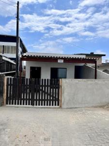 a house with a wooden fence in front of it at Casa Beira Mar in Matinhos