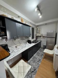 a kitchen with black cabinets and a marble counter top at Miri Apartament in Lupeni