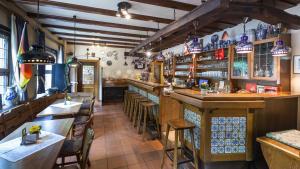 a restaurant with a bar with tables and chairs at Urfter Hof Garni in Kall