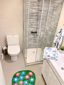 a bathroom with a shower and a toilet and a green rug at Monte do Garnacho - Villa in the Mountains in Sertã +26 photos