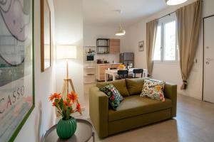 a living room with a couch and a table with flowers at MagliaNeraApartment in Quartu SantʼElena
