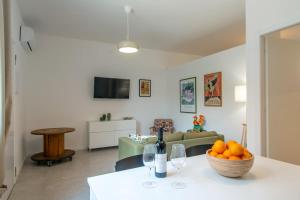 a living room with a table with a bowl of oranges at MagliaNeraApartment in Quartu Sant'Elena