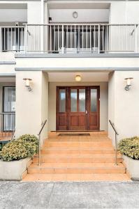 a house with a wooden door and a balcony at Kingsland Big Family Comfort House in Auckland