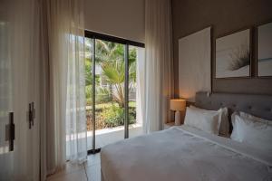 ein Schlafzimmer mit einem Bett und einem großen Fenster in der Unterkunft Apartment in a Tropical Oasis, Ki Residences, Pereybere - Managed by KSN in Pereybere + 40 Fotos