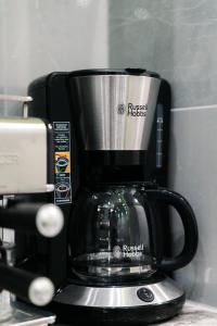 a coffee pot sitting on top of a coffeemaker at White House Apartman Miskolc, Green Room in Miskolc +22 photos