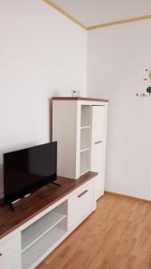 a living room with a tv and a white cabinet at Apartament Central in Piatra Neamţ