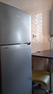 a refrigerator in a kitchen with a table and a chair at Apartament Central in Piatra Neamţ