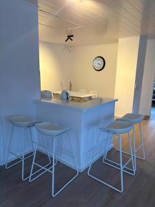 a kitchen with a counter with stools and a clock at Moselfreunde Ellenz-Poltersdorf in Ellenz-Poltersdorf
