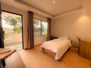 a bedroom with a bed and a large window at Tharlam Guest House in Kathmandu