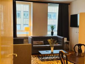 a living room with a couch and a table at STAY Kamppi Center Apartment in Helsinki