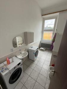 ein Badezimmer mit Waschmaschine und Waschbecken in der Unterkunft Exclusive Monteursunterkunft in Kirchenlamitz