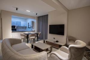 a living room with a tv and a table and chairs at The D9 Luxury Suites - Hurghada in Hurghada