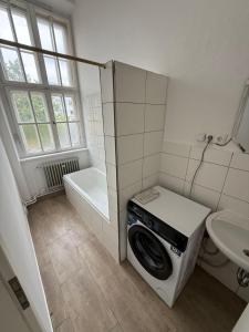 ein Badezimmer mit Waschmaschine und Waschbecken in der Unterkunft Exclusive Monteursunterkunft in Kirchenlamitz