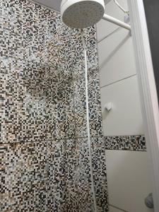 a bathroom with a shower with a mosaic wall at Casa bem aconchegante ao lado do teleferico in Bonito