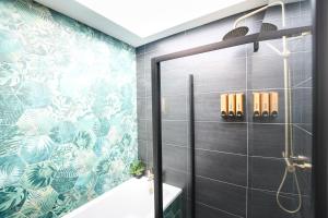 a bathroom with a shower and a tile wall at Northern Hideaways, The Nest Ponteland in Newcastle upon Tyne