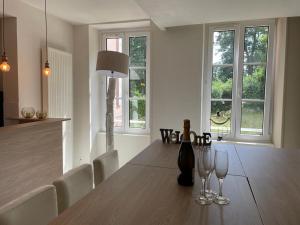 a dining room with a table with two wine glasses at Régina Colmar Vignoble jusqu'à 10 personnes in Trois-Épis