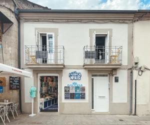a white building with two balconies on top of it at Go Compostela Apartamento 4 pax in Sarria